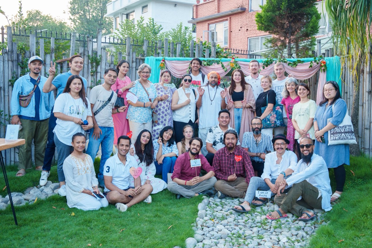 Eine Gruppe von Teilnehmenden lächelt gemeinsam in einem Garten